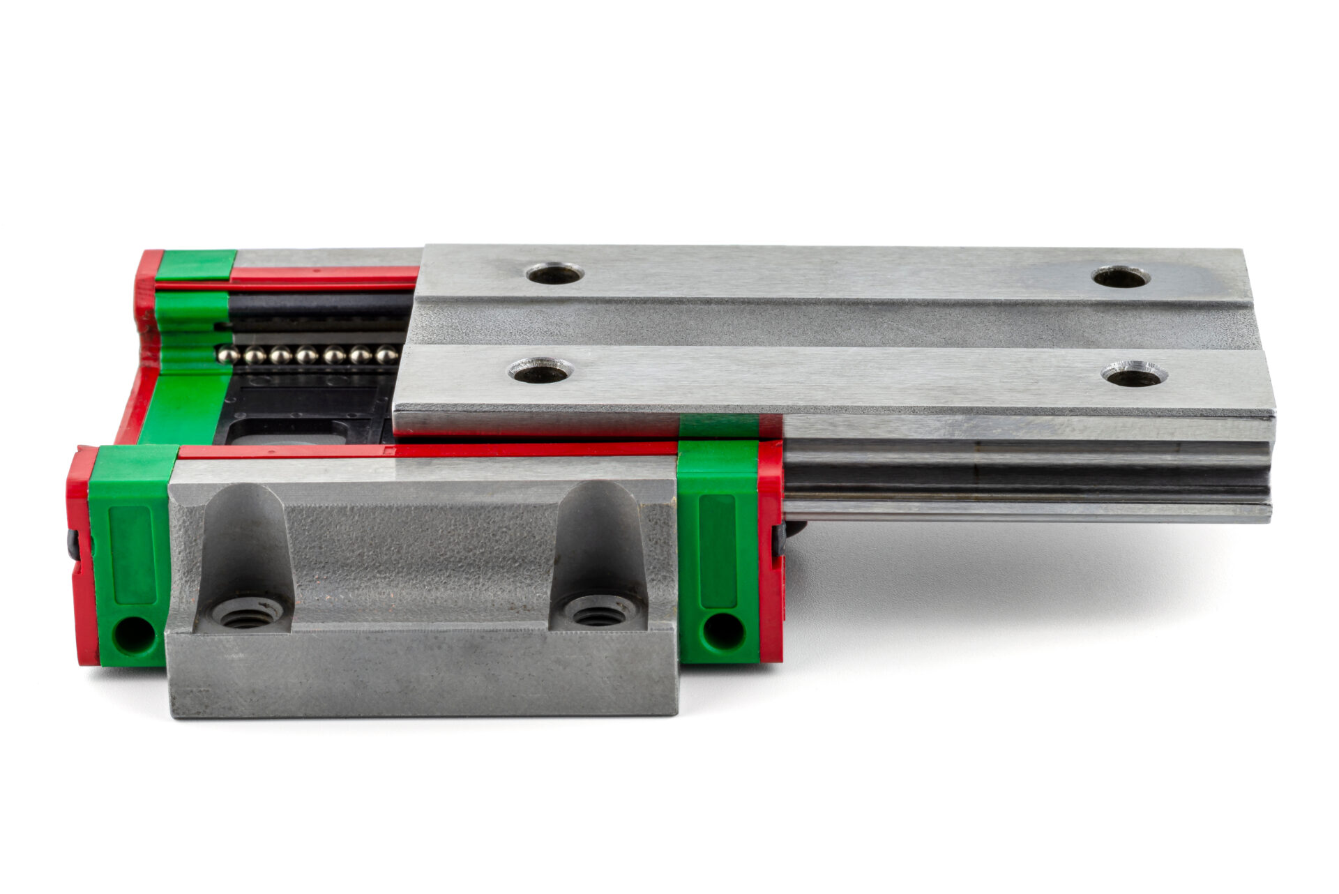 Macro photo of a old linear bearing with a linear trolley, isolated on a white background.